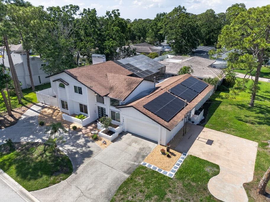 An aerial view of a two-story house with solar panels on the garage roof — 1461 87TH AVENUE N, ST PETERSBURG, FL