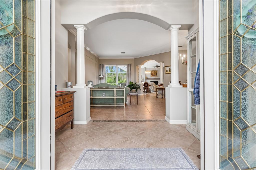 A view from a doorway into a tiled foyer with columns leading to a living area — 23305 GRACEWOOD CIRCLE, LAND O LAKES, FL
