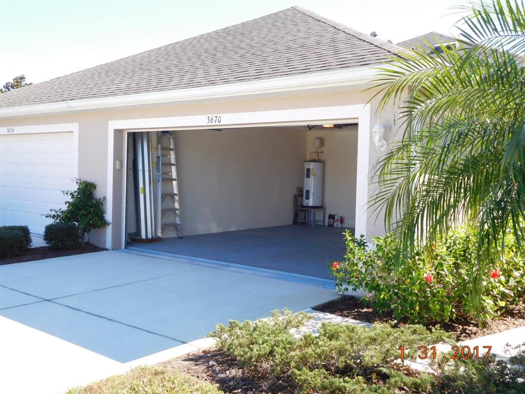 An open garage with a water heater and a ladder visible from the driveway — 3670 LAKEWOOD BOULEVARD, NORTH PORT, FL