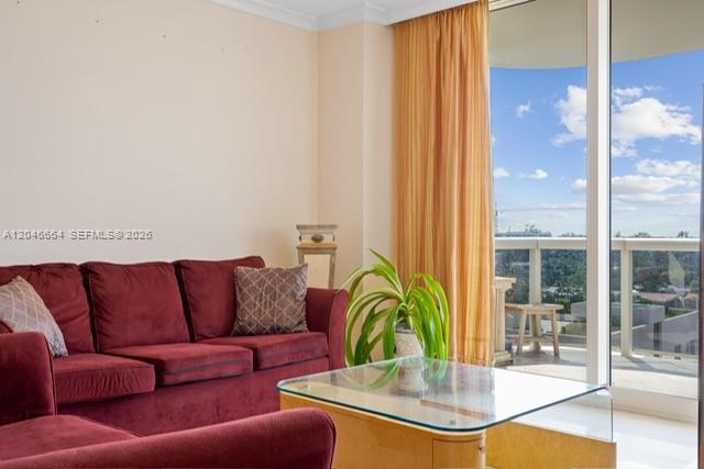 A living room features a red sofa, a glass coffee table, and a balcony view — SURFSIDE, FL