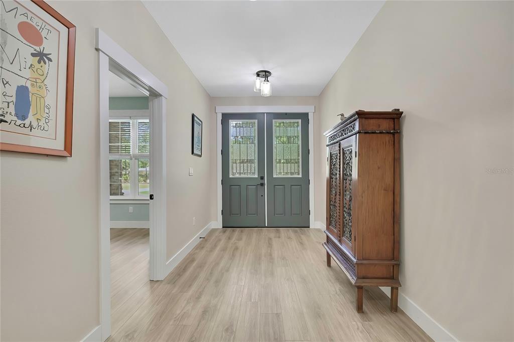 A foyer features light wood-look flooring, a tall wooden cabinet, and a dark double door — 3991 N BUCKHORN DRIVE, BEVERLY HILLS, FL