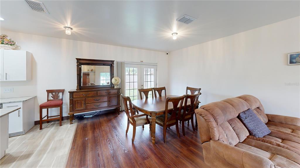 A dining area features a wooden table, chairs, a sideboard, and a brown sofa — 402 E MAPLE STREET, WINTER GARDEN, FL