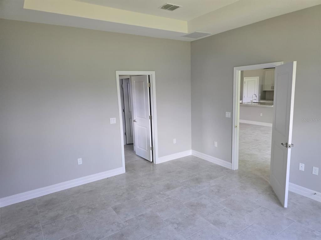 A room with light gray walls, tile flooring, and two open doorways leading to other areas — 2857 SHADY AVENUE, NORTH PORT, FL