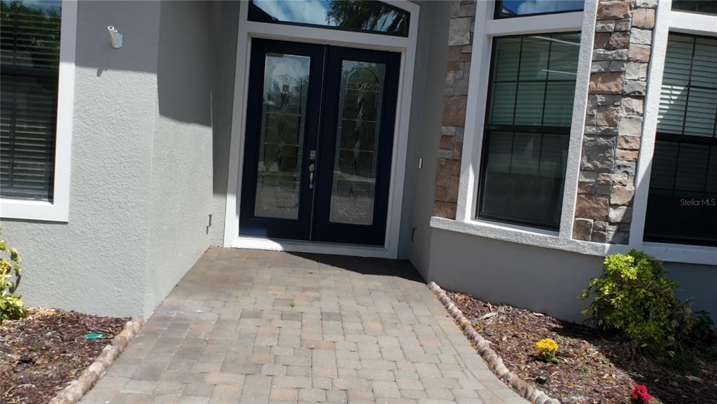 A single-story house with a stone facade, a paved driveway, and two garage doors — 2120 SOUTHERN OAKS LANE, LAKELAND, FL
