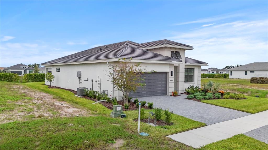 A single-story house with a gray tile roof, stucco exterior, and a paved driveway — 18119 CRESSWIND TERRACE, LAKEWOOD RANCH, FL