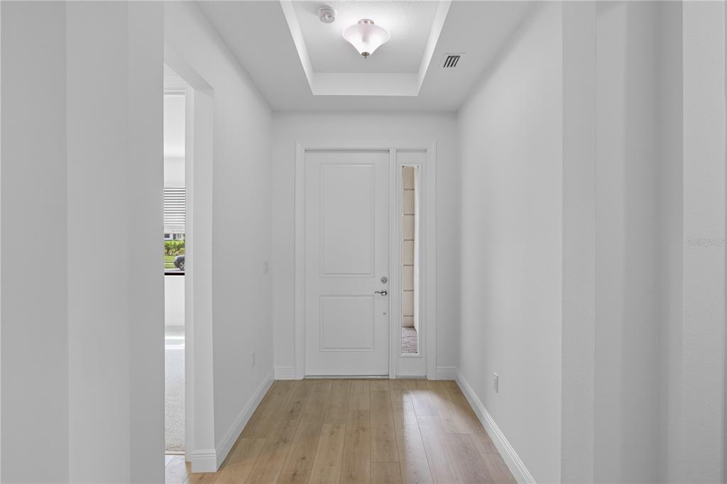 A bright entryway features light wood flooring, white walls, and a recessed ceiling light — 18119 CRESSWIND TERRACE, LAKEWOOD RANCH, FL