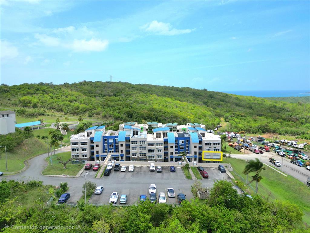 An aerial view shows a multi-story apartment building with a parking lot and surrounding hills — 3 ST. MIRADOR PLAYA CONVENTO UNIT 10204, FAJARDO, PR