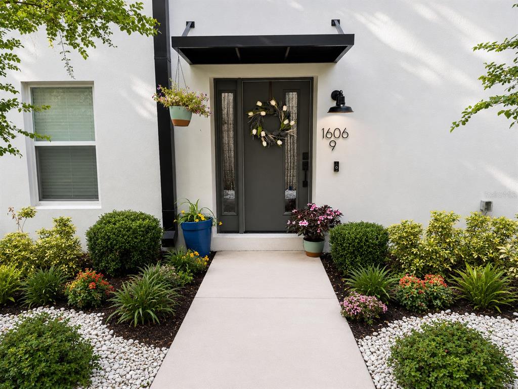 A modern front entrance features a gray door, a black awning, and landscaped garden beds — 1606 PARK LAKE STREET UNIT 9, ORLANDO, FL