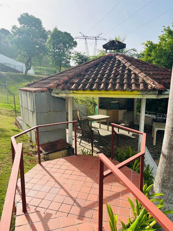 An outdoor gazebo with a tiled roof and floor features a small kitchen and seating area — Bo. Dajao Cam Los Oyola BO. DAJAO, BAYAMON, PR
