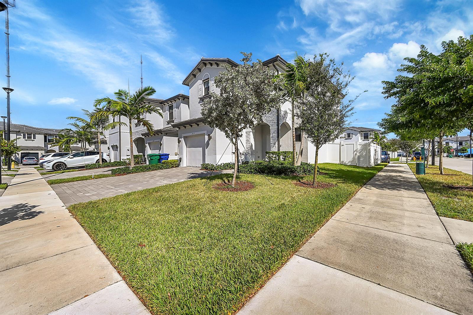 A two-story suburban house with a paved driveway, front lawn, and palm trees — 20357 NW 4th Path, Miami Gardens FL 33169, MIAMI GARDENS, FL