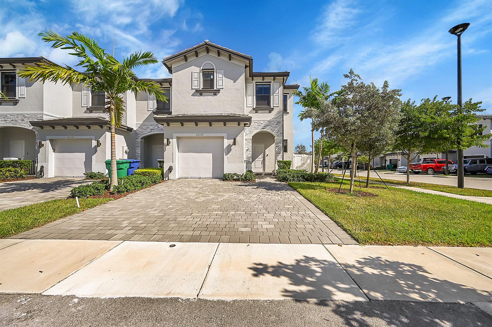 A two-story townhouse with a paved driveway, a one-car garage, and a palm tree — 20357 NW 4th Path, Miami Gardens FL 33169, MIAMI GARDENS, FL