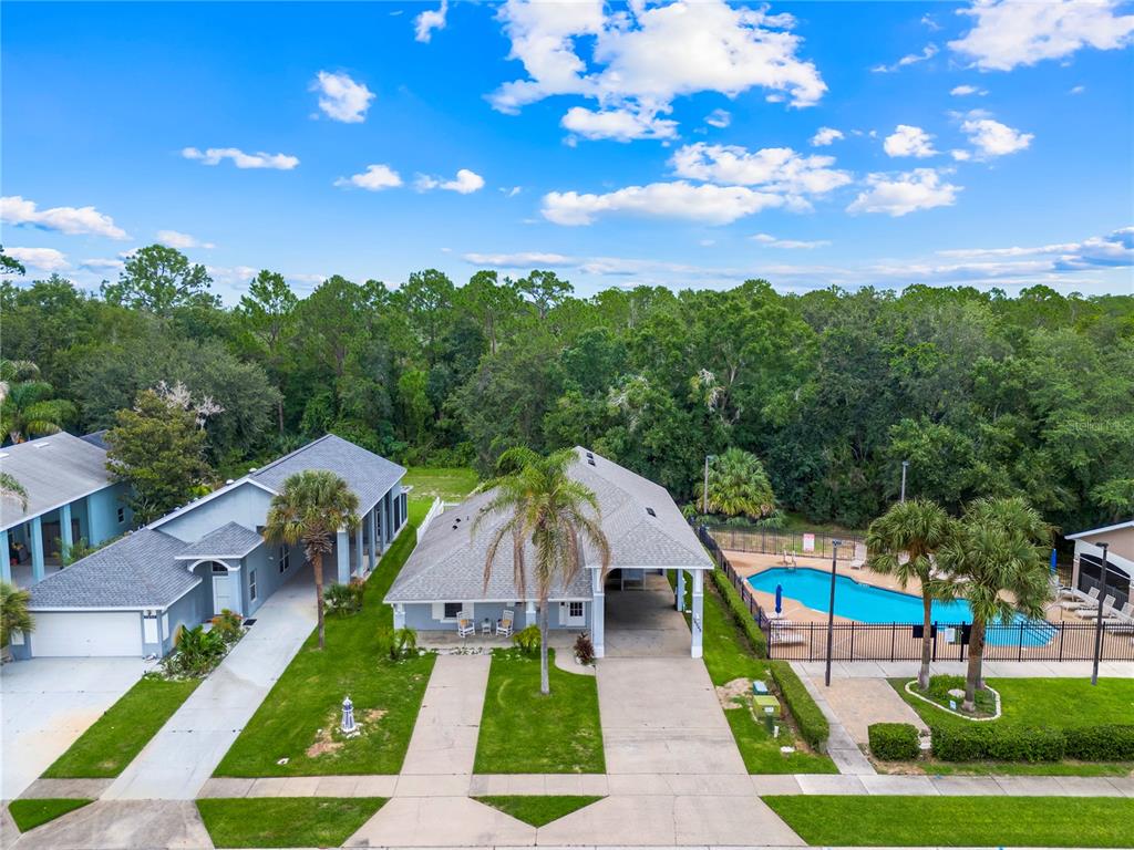 An aerial view shows two suburban houses with driveways, lawns, and a shared swimming pool — 16345 CITRUS PARKWAY, CLERMONT, FL