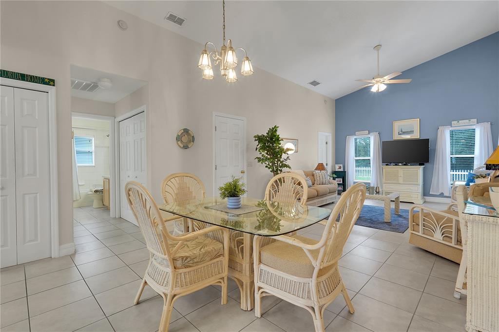 A dining area with a glass table and wicker chairs opens into a living room — 16345 CITRUS PARKWAY, CLERMONT, FL