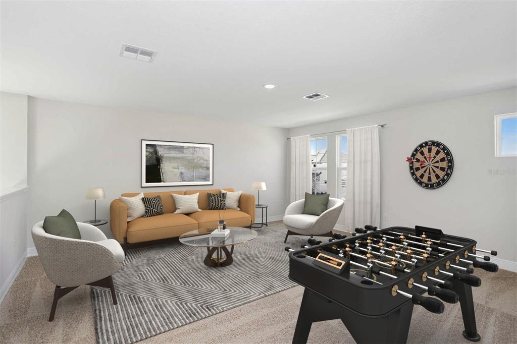 This is a digitally staged living room featuring a sofa, armchairs, and a foosball table — 33595 TWILIGHT SEA PLACE, DADE CITY, FL