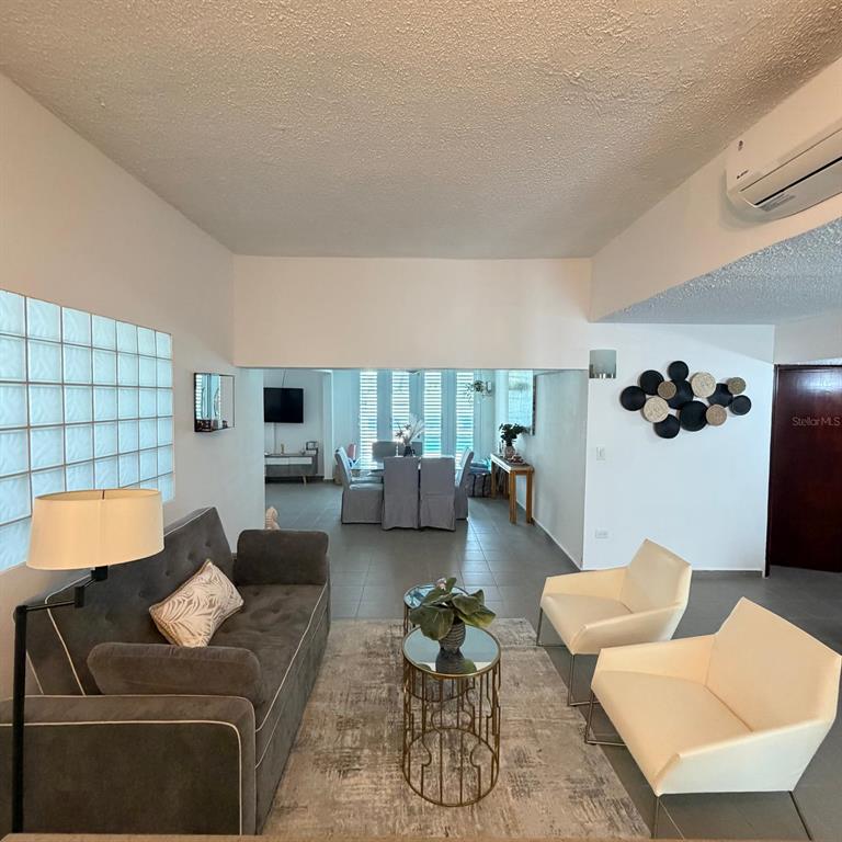 A living room with a gray sofa, two white chairs, and a dining area beyond — Marullo 5 DORADO DEL MAR UNIT O5, DORADO, PR