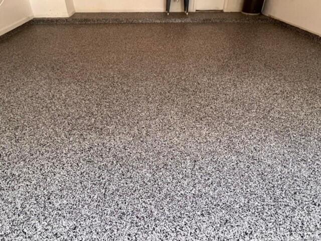 A garage floor features a speckled gray and black epoxy finish with a matching coved base — 10330 Copper Lake Drive, Boynton Beach FL 33437, BOYNTON BEACH, FL