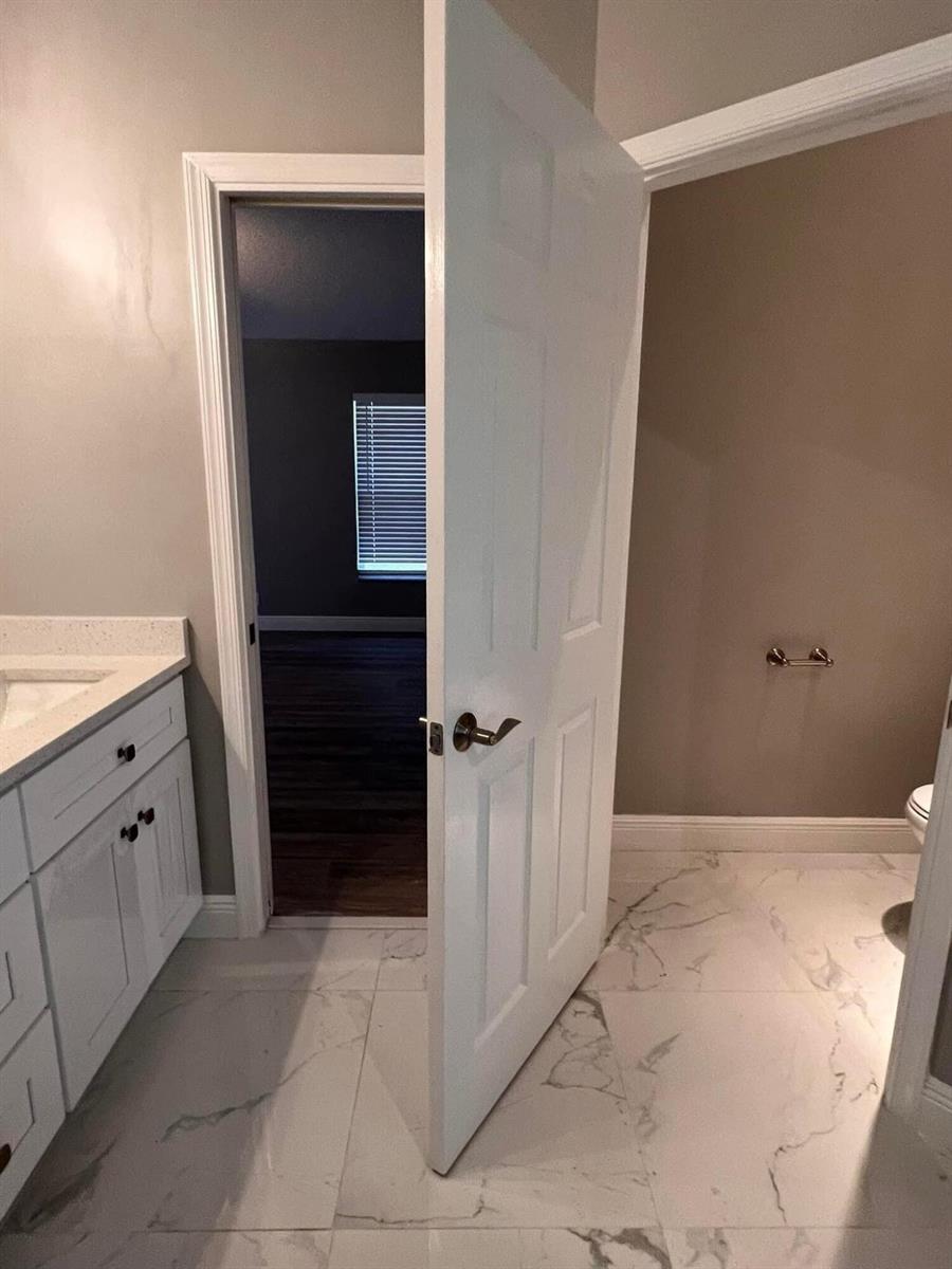 A white door stands open between a tiled bathroom and a room with dark flooring — 10330 Copper Lake Drive, Boynton Beach FL 33437, BOYNTON BEACH, FL