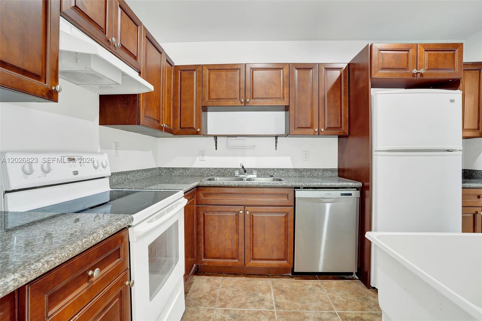 A kitchen features dark wood cabinets, granite countertops, white appliances, and a stainless steel dishwasher — 5985 SW 41st St, Miami FL 33155, MIAMI, FL