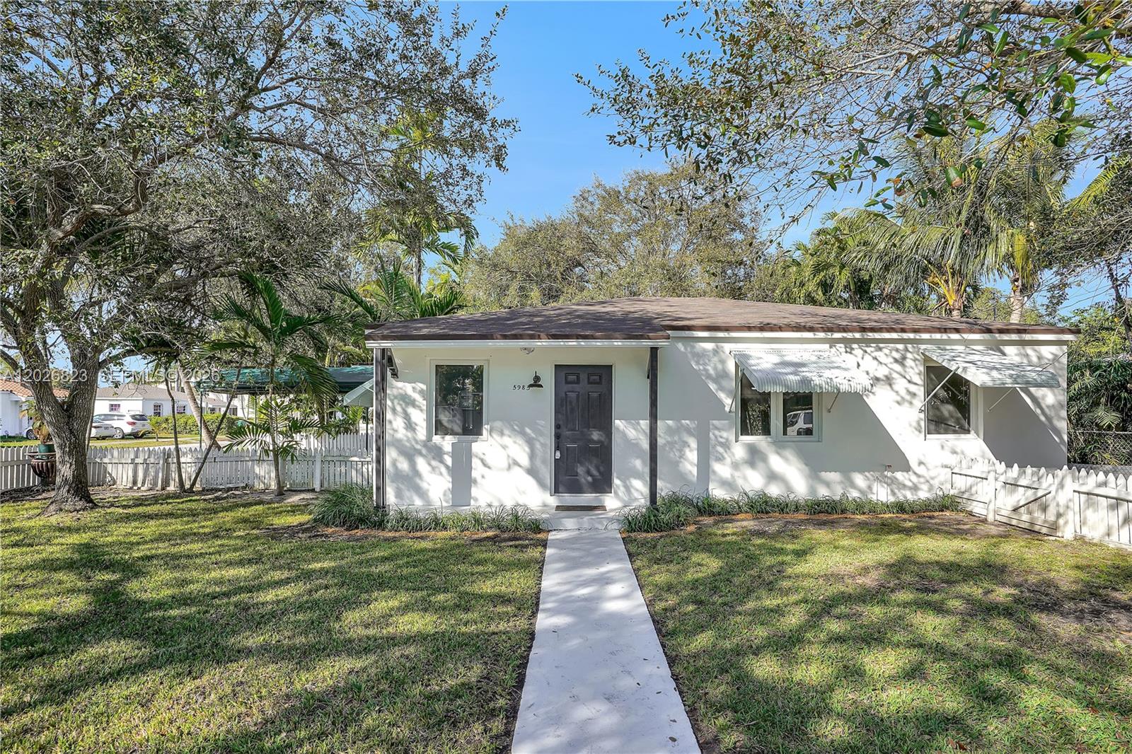 A single-story white house with a dark front door and a concrete walkway — 5985 SW 41st St, Miami FL 33155, MIAMI, FL