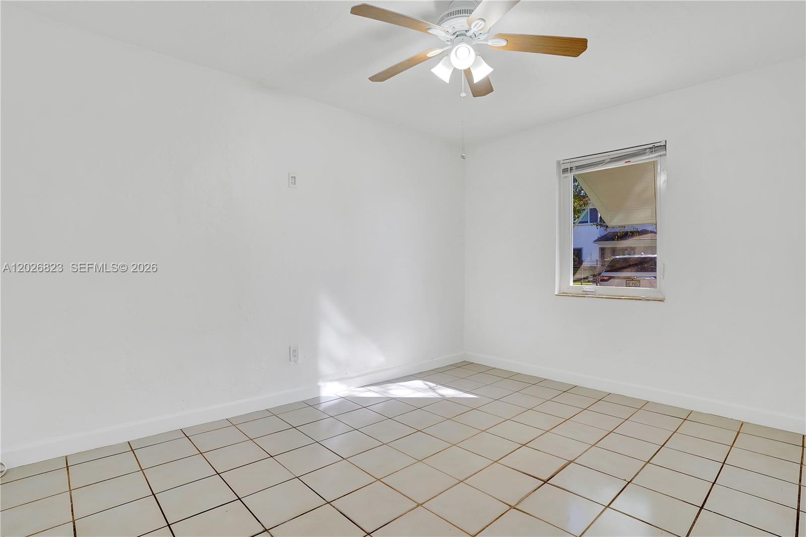An empty room features white walls, a tiled floor, and a ceiling fan — 5985 SW 41st St, Miami FL 33155, MIAMI, FL