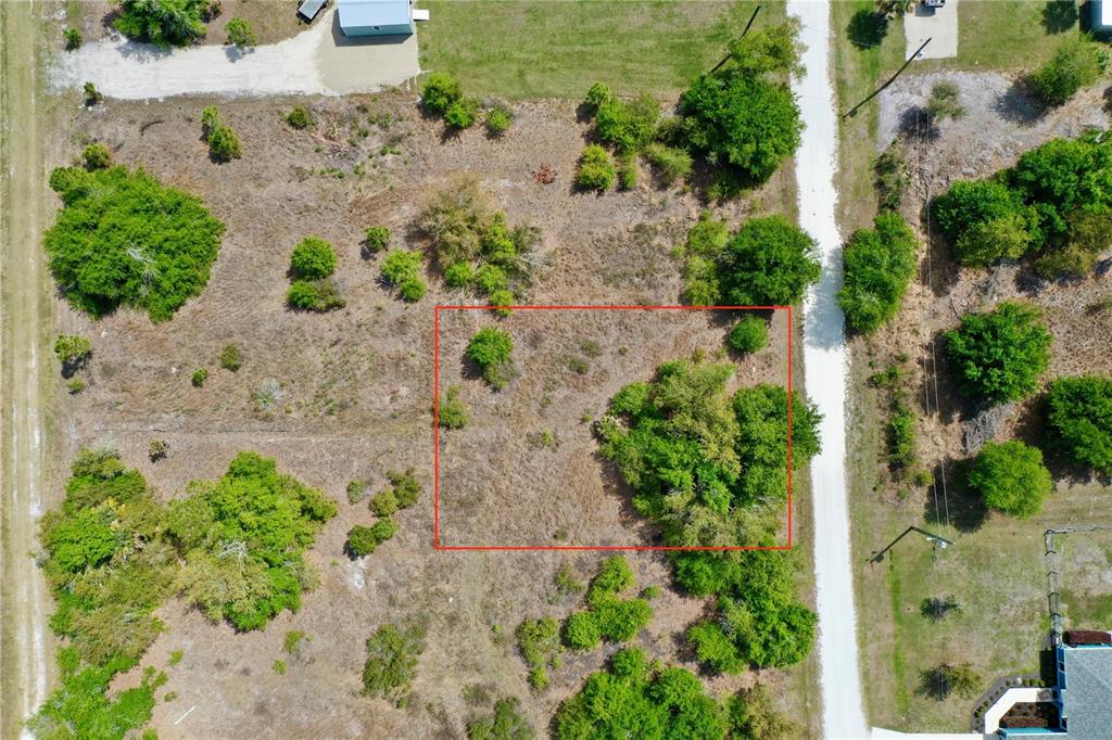 An aerial view shows a rectangular vacant lot outlined in red next to a road — 27054 MINGO DRIVE, PUNTA GORDA, FL