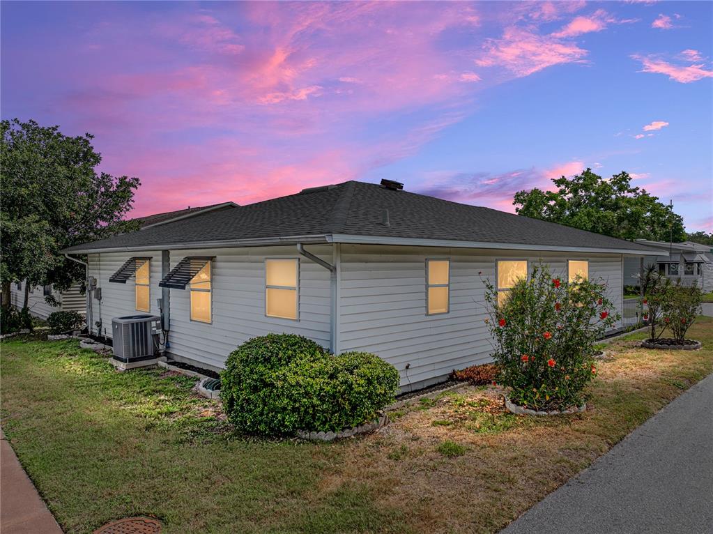 The exterior of a single-story house with white siding and a dark shingled roof — 4965 GOLDENVIEW LANE, LAKELAND, FL