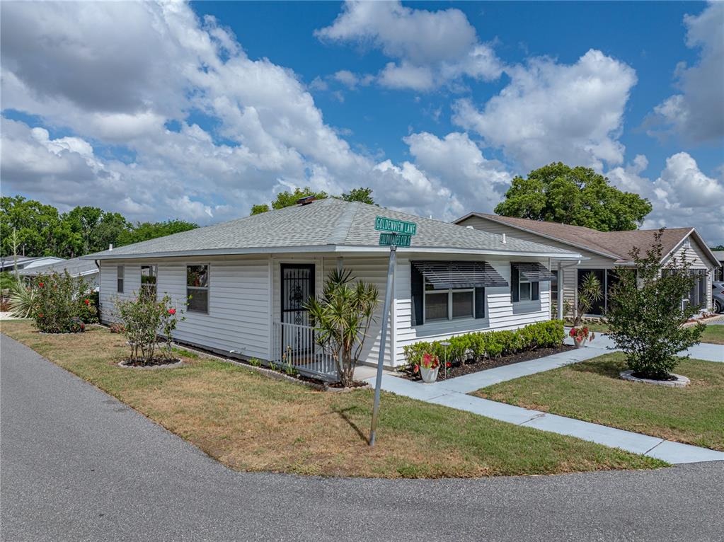 A white, single-story house with a hip roof sits on a corner lot — 4965 GOLDENVIEW LANE, LAKELAND, FL