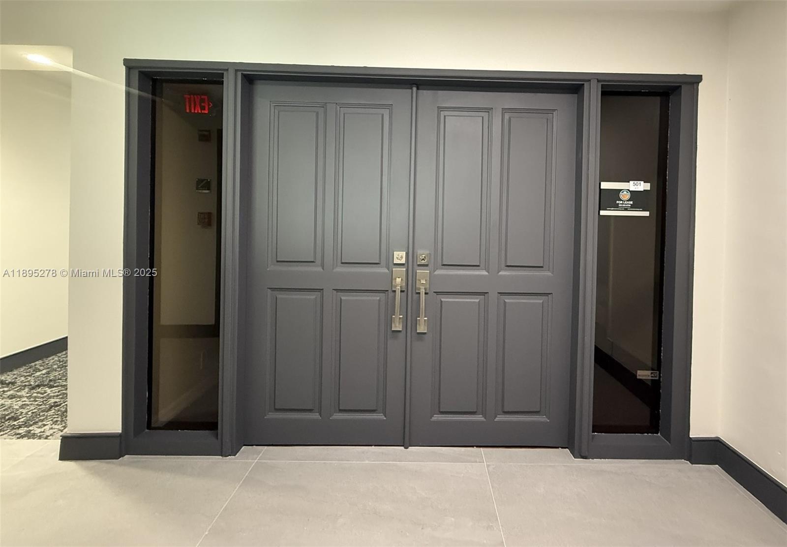 A set of dark gray double doors with sidelights and silver hardware in a hallway — 299 Alhambra Cir, Coral Gables FL 33134, CORAL GABLES, FL