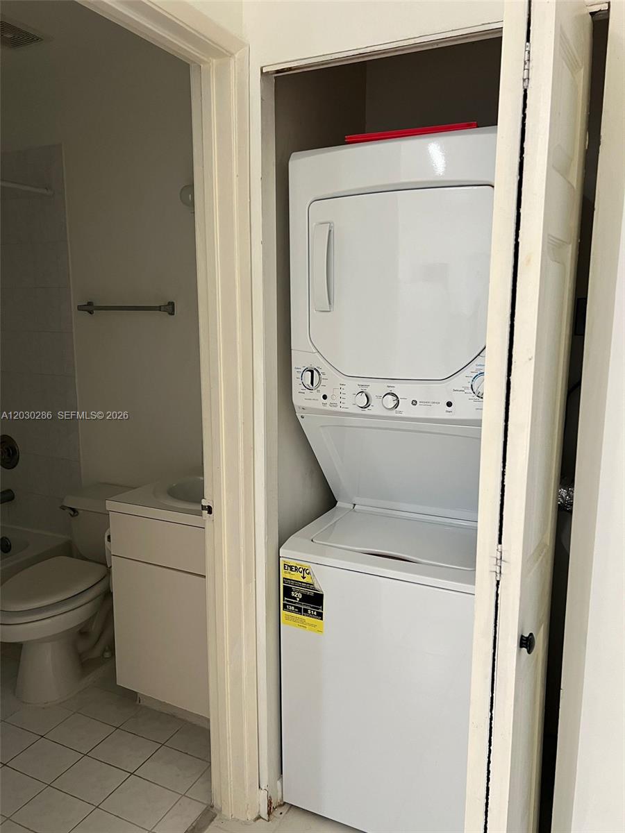 A stacked washer and dryer unit is located in a closet next to a bathroom — 15315 SW 76th Ter # 207, Miami FL 33193, MIAMI, FL