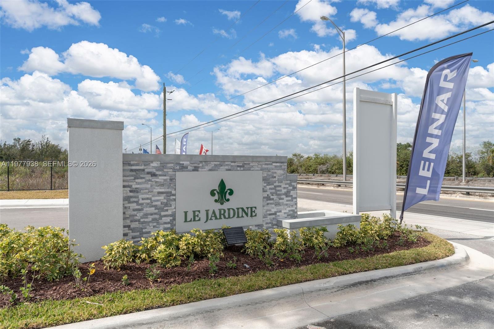 A stone monument sign for Le Jardine stands in a landscaped area near a road — 191 SE 11th Ave, Florida City FL 33034, FLORIDA CITY, FL