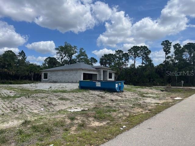 A single-story house under construction sits on a lot with a blue dumpster nearby — SCOTTISH TERRACE, NORTH PORT, FL