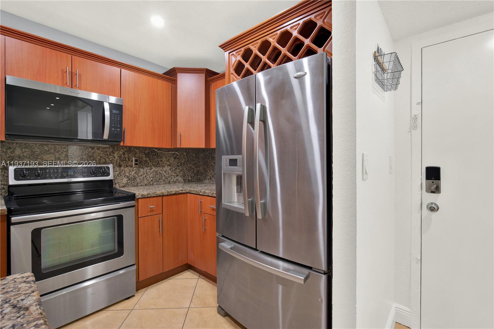 A kitchen features stainless steel appliances, wood cabinets, and granite countertops — 5665 W 20th Ave # 415, Hialeah FL 33012, HIALEAH, FL