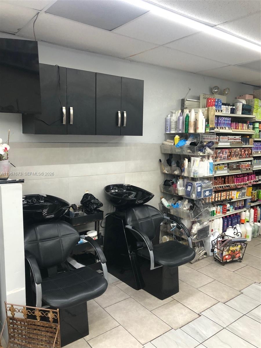 This hair salon features two black shampoo stations and a shelving unit filled with products — 57th, Miami Gardens FL 33055, MIAMI GARDENS, FL