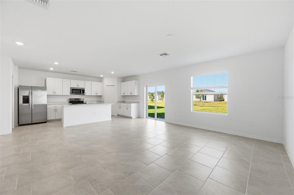 An empty garage with a concrete floor, white block walls, and a metal sectional door — 13413 TURNLEAF BOULEVARD, PUNTA GORDA, FL