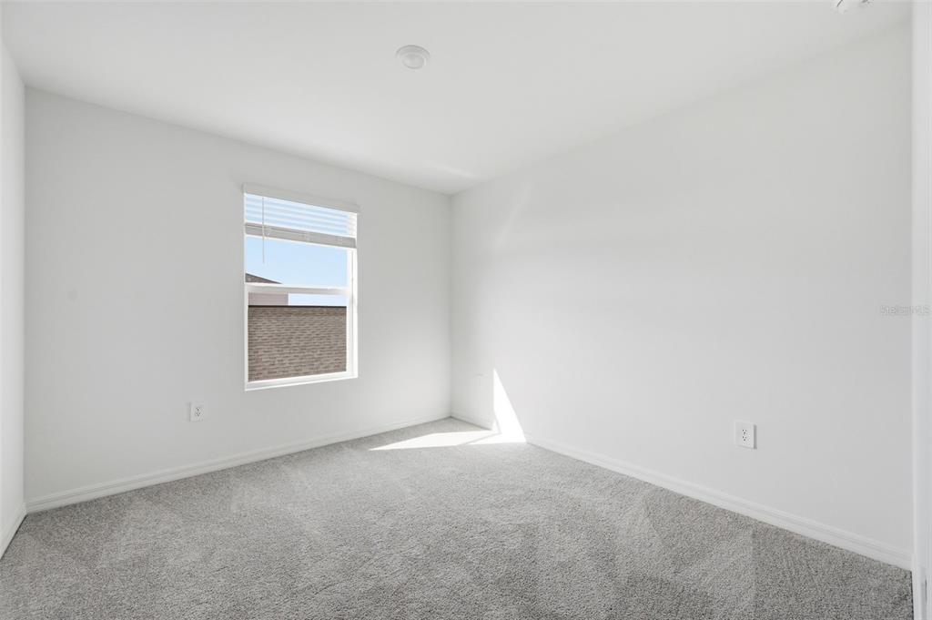 A modern kitchen features white cabinets, stainless steel appliances, a center island, and tile flooring — 13413 TURNLEAF BOULEVARD, PUNTA GORDA, FL