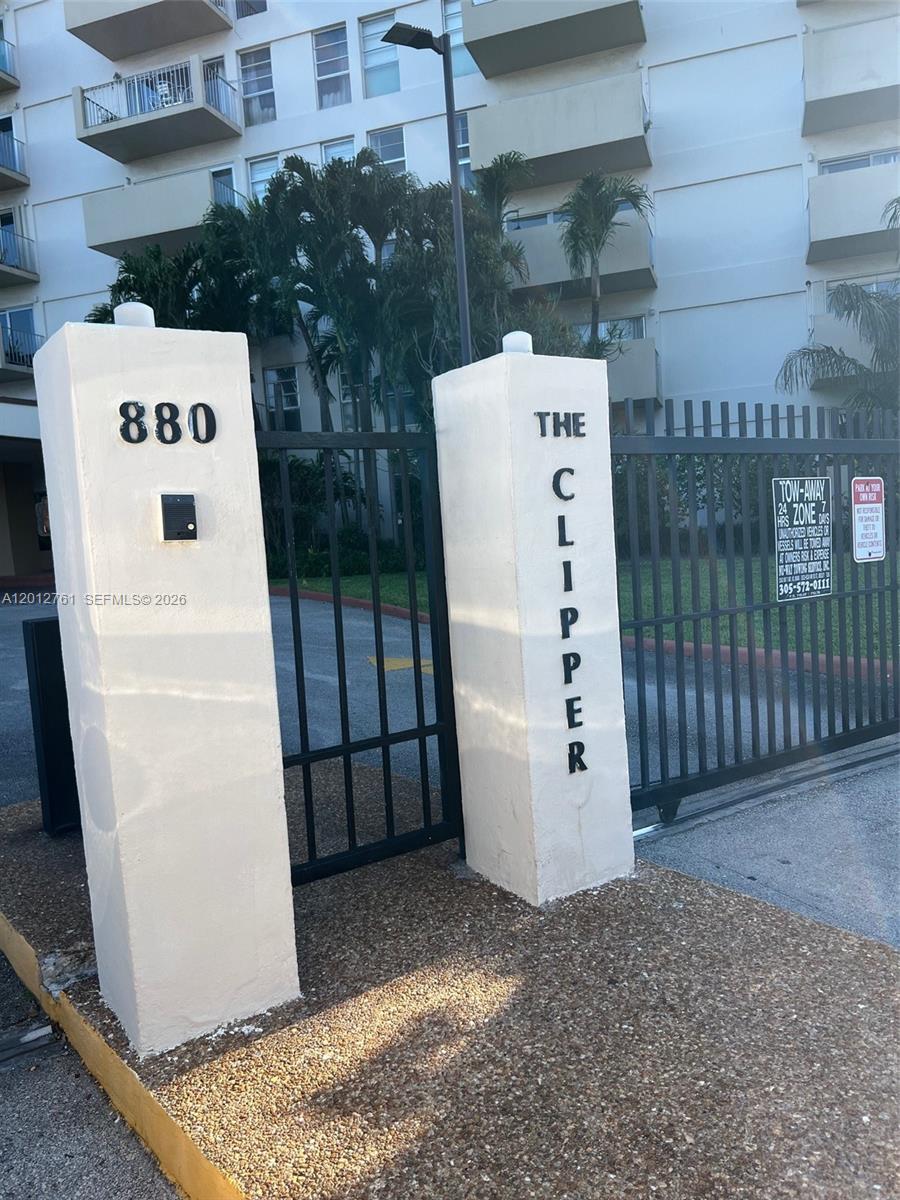 A gated entrance with two concrete pillars labeled with the building name and address — 880 NE 69th St # 11M, Miami FL 33138, MIAMI, FL