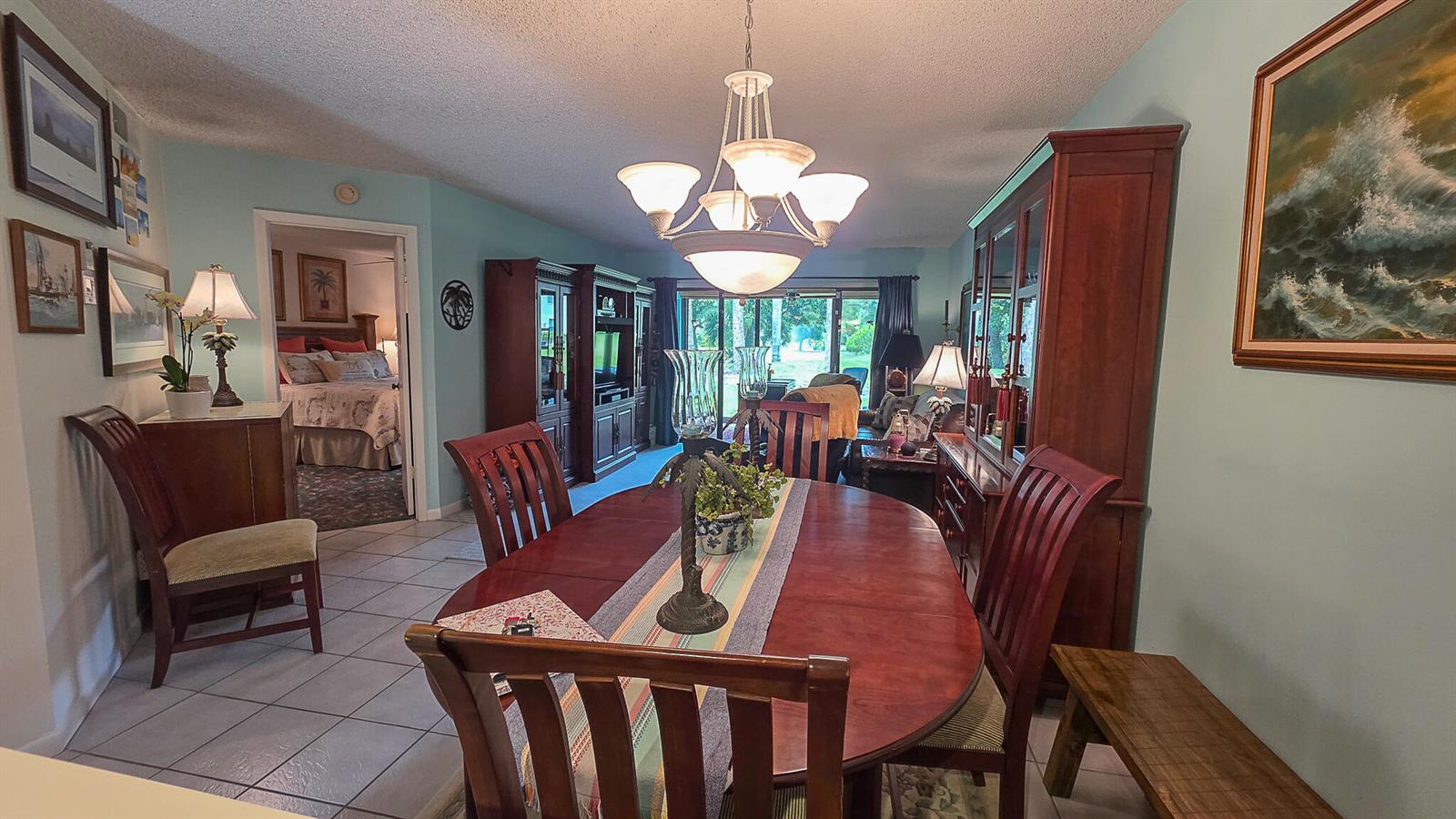 A dining room with a wooden table, chairs, a china cabinet, and a chandelier — 3349 Perimeter Drive, FL 33467, FL