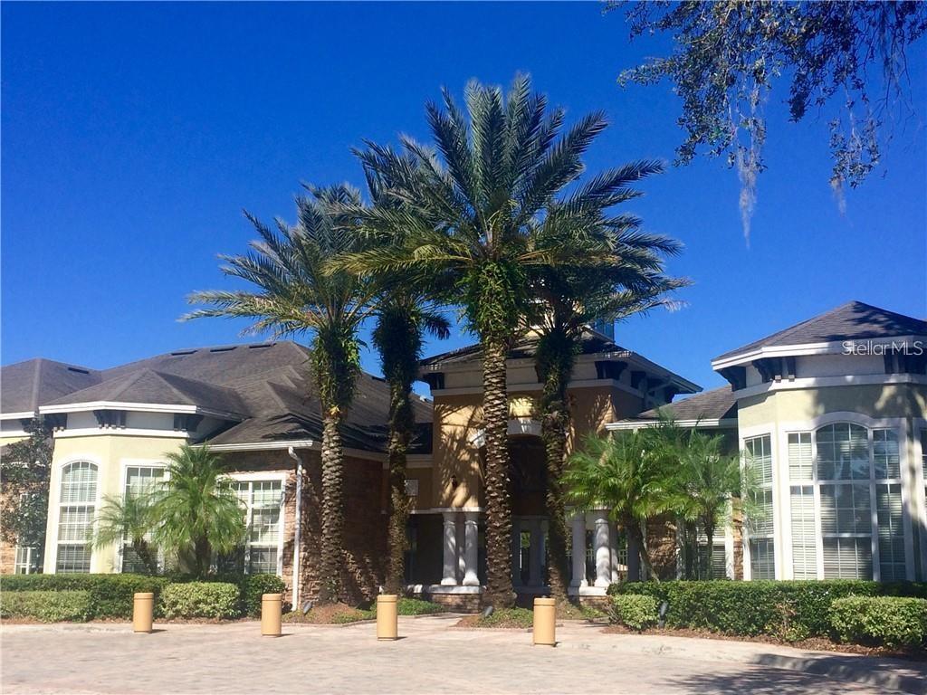 A large house with a stone and stucco exterior features tall palm trees in front — 10025 COURTNEY PALMS  BOULEVARD UNIT 103, TAMPA, FL