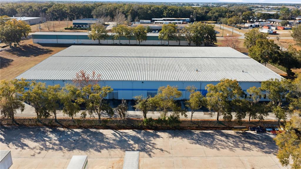 An aerial view of a large industrial warehouse building with a metal roof and loading docks — 451 SW 57TH AVENUE, OCALA, FL