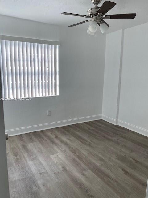 An empty room features light gray wood-look flooring, white walls, vertical blinds, and a ceiling fan — 5960 NE 5th Ct # 4, Miami FL 33137, MIAMI, FL
