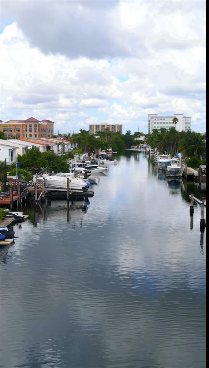 A canal view features multiple docked boats alongside residential buildings and a fitness center — 2035 NE 123rd St, North Miami FL 33181, NORTH MIAMI, FL