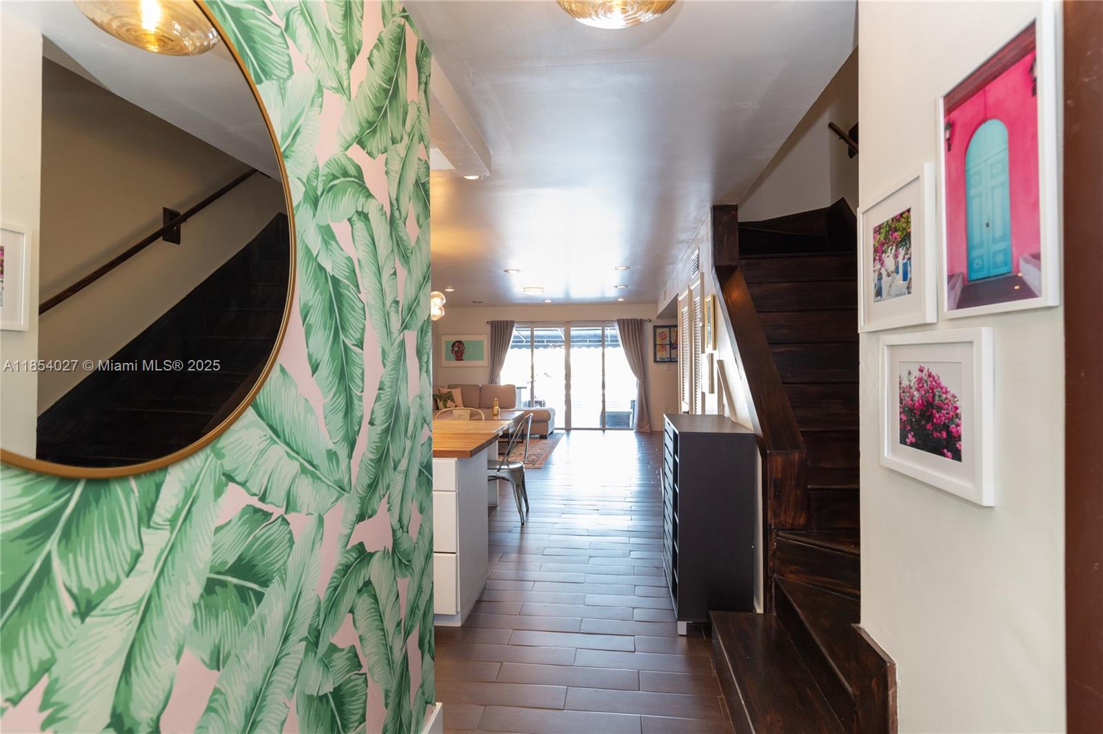 An interior view shows a hallway with tropical wallpaper, dark wood stairs, and a kitchen — 2035 NE 123rd St, North Miami FL 33181, NORTH MIAMI, FL