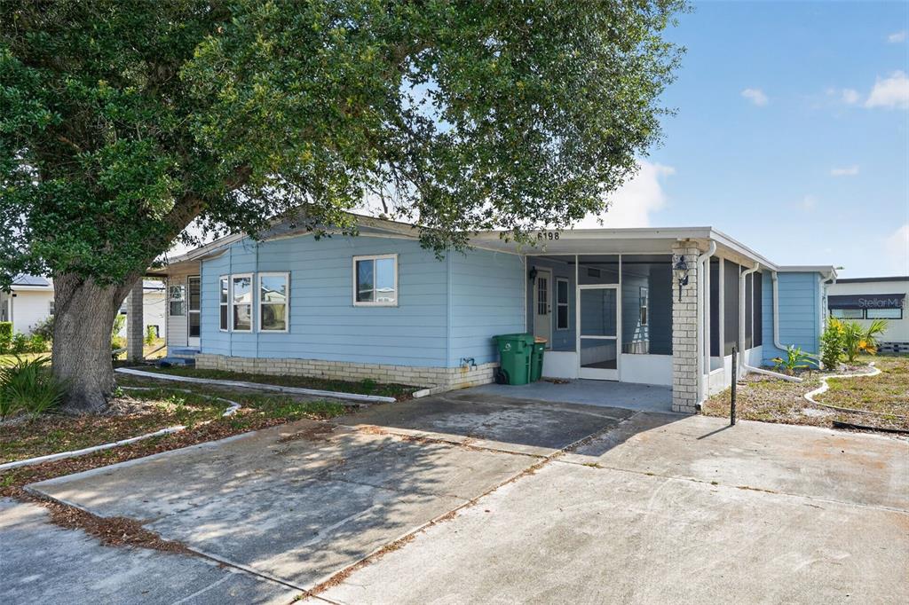 A light blue mobile home with a screened-in porch and a concrete driveway — 6198 ORIOLE BOULEVARD, ENGLEWOOD, FL