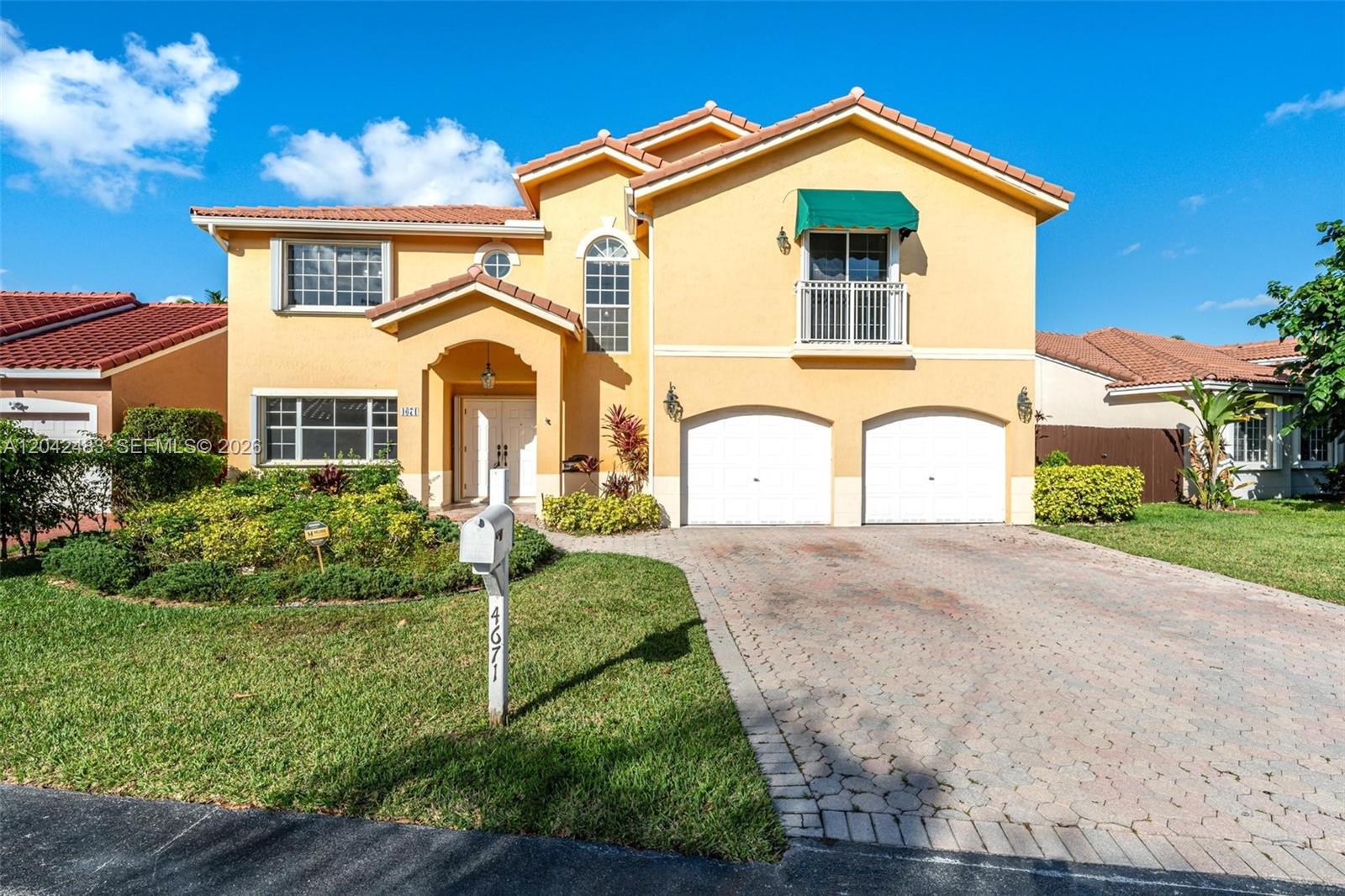 A two-story yellow stucco house features a tiled roof, a two-car garage, and a driveway — 4671 SW 154th Pl, Miami FL 33185, MIAMI, FL