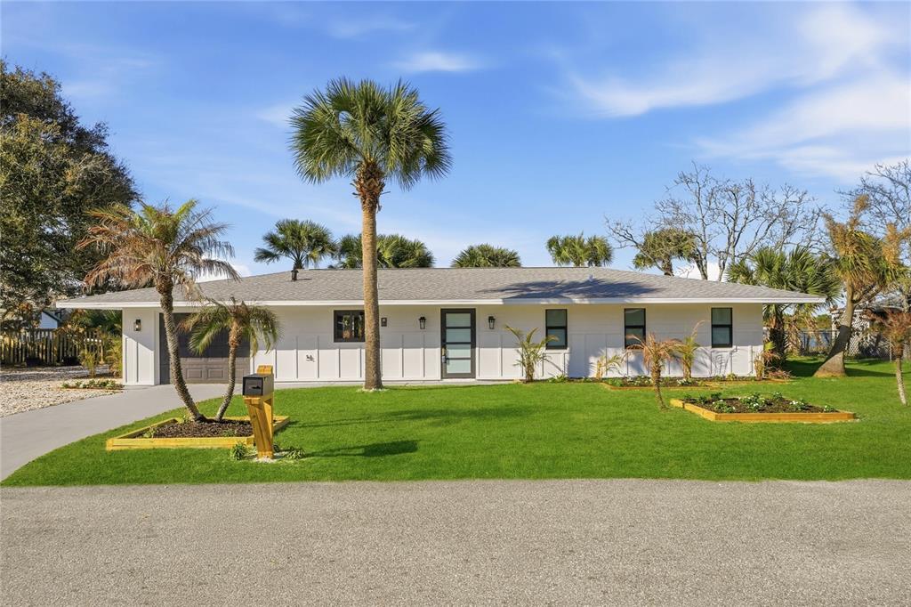 A single-story white house with a gray roof, palm trees, and a green lawn — 203 PARKWOOD LANE, EDGEWATER, FL