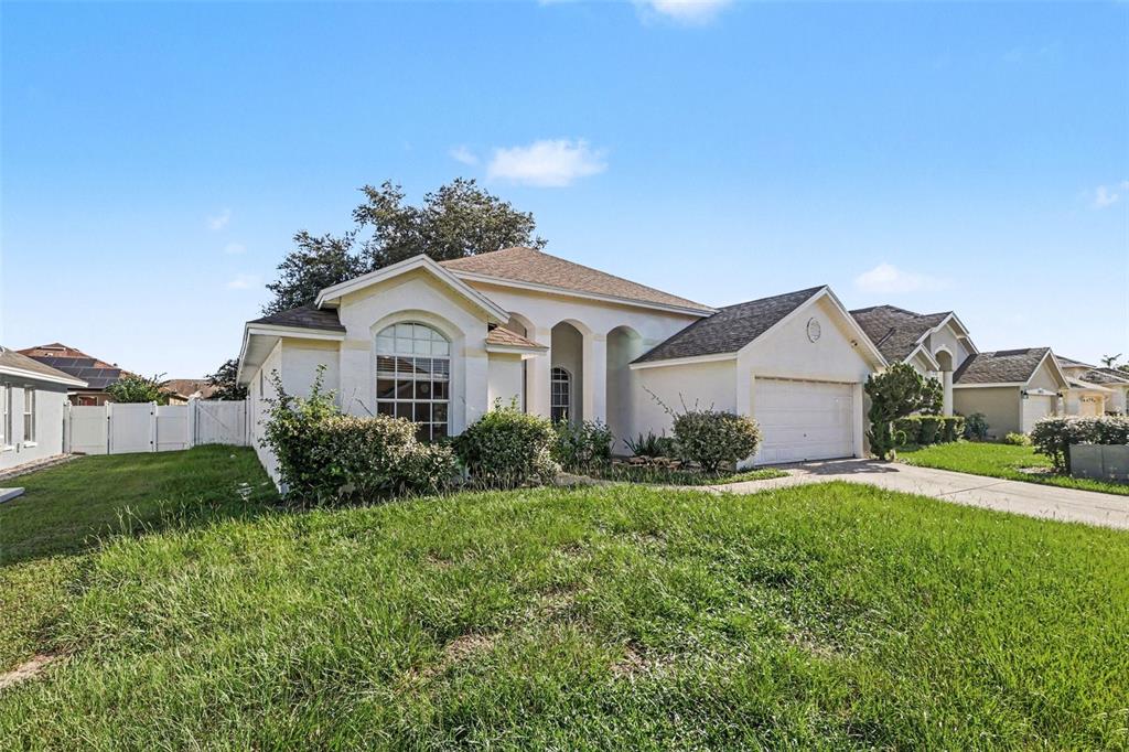 A single-story suburban house with a stucco exterior, arched entryway, and an attached garage — 28809 WINDOVER ST, WESLEY CHAPEL, FL