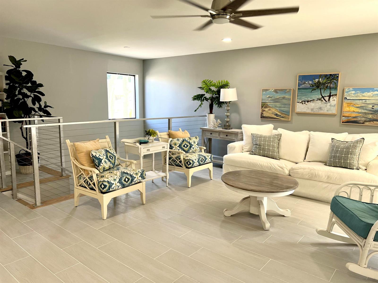 A living room features a white sofa, patterned armchairs, a round coffee table, and artwork — 17081 Waterbend Dr Drive Unit 229, Jupiter FL 33477, JUPITER, FL