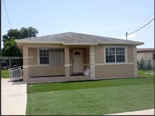 A single-story house with a tan exterior, a covered front porch, and a green lawn — 516 NW 4th Ave, Hallandale Beach FL 33009, HALLANDALE BEACH, FL