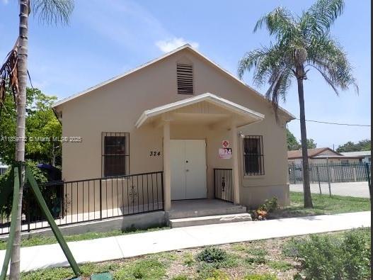 A beige, single-story building with a front porch, metal railings, and a palm tree — 516 NW 4th Ave, Hallandale Beach FL 33009, HALLANDALE BEACH, FL