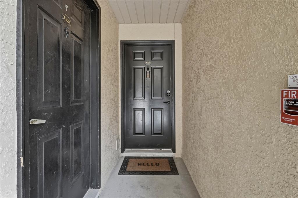 A kitchen with white cabinets, stainless steel appliances, and a breakfast bar overlooking the dining area — 2400 FEATHER SOUND DRIVE UNIT 427, CLEARWATER, FL